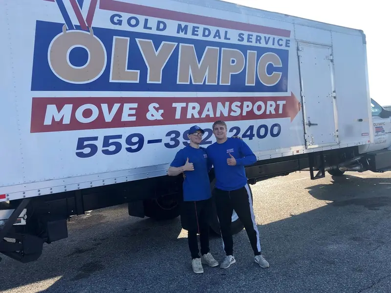 Olympic crew members with young helpers in front of a company truck