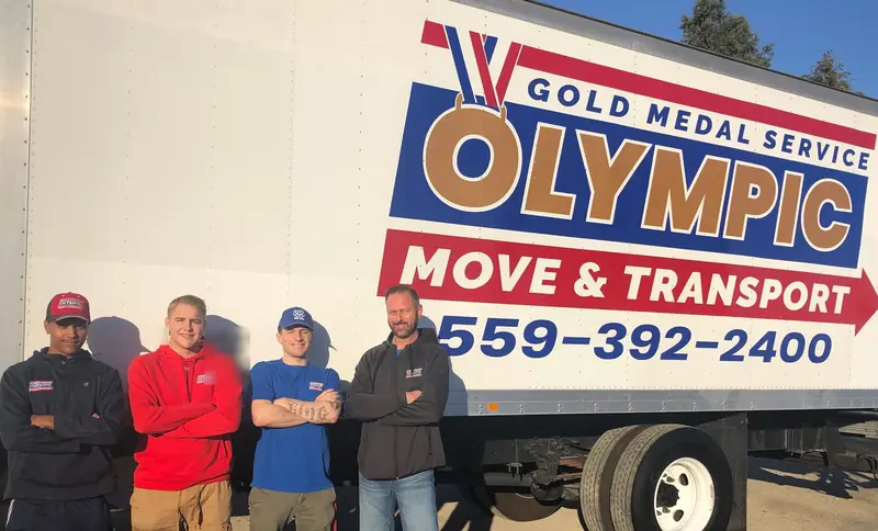 Olympic Move & Transport team lined up beside a company truck