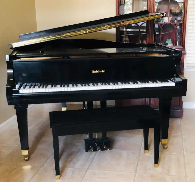 Black grand piano set up in its new room after a move
