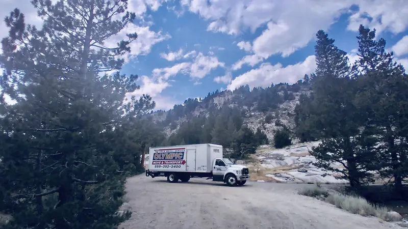 Olympic moving truck on a winding mountain road